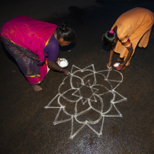 Women In Sari Bent Down Drawing Kolam In The Street, Trichy, India