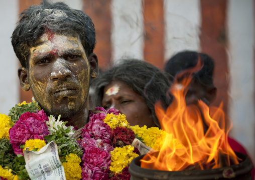Man Wearing A Flower Garland And Covered With Ashes And Yellow Paste Behind A Jar On Fire During Fire Walking Ritual, Madurai, South India
