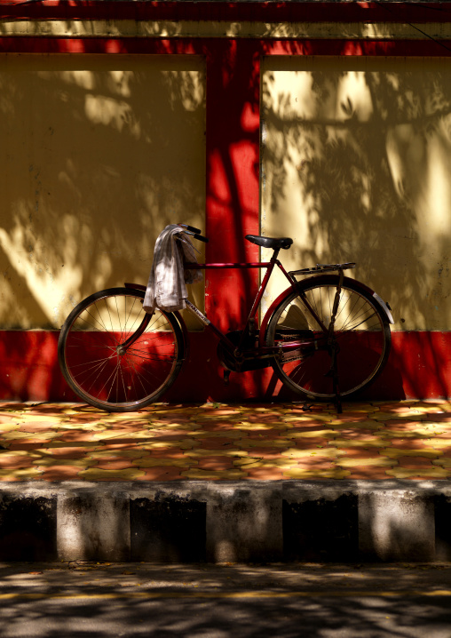 Red Bicycle On Kickstand Parked On A Sidewalk In The Shade, Pondicherry, India