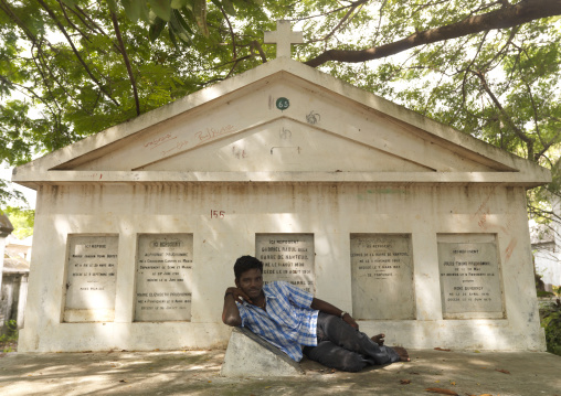 Young Man Lying In Front Of A French Grave In A Cemetery, Pondicherry, India