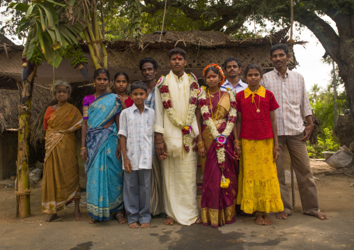 Young Bride And Groom  Dressed For The Ceremony And Adorned With Flower Garlands Posing Surrounded By Family, Pondicherry, India