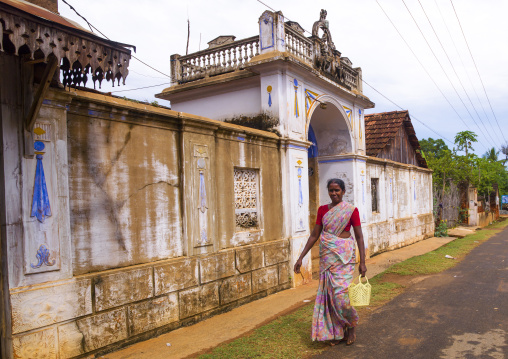 Woman Holding A Plastic Basket In Her Hand Walking Alongside The Gateway Of An Old Chettiar Mansion, Kanadukathan Chettinad, India