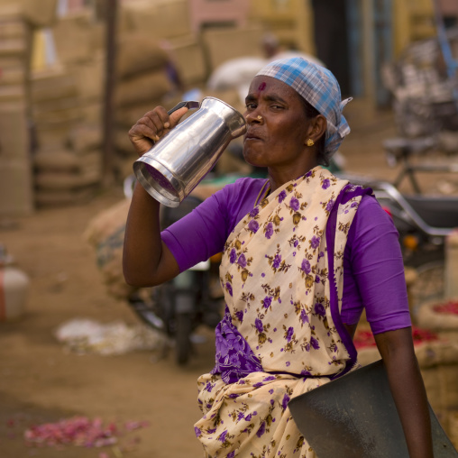 Woman Starring At The Camera While Drinking Water At Madurai Market , India
