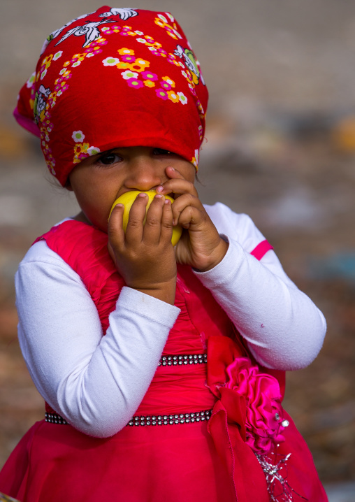 little girl bites in an apple, Hormozgan, Minab, Iran