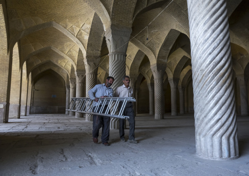 Workers passing in the vakil mosque prayer hall, Fars province, Shiraz, Iran