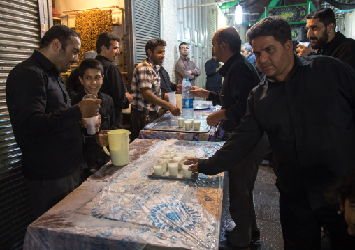Shiite men offering free milk in the bazaar as nazri during Muharram, Isfahan Province, Isfahan, Iran