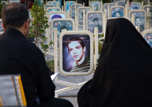 Parents on the tomb of their son killed in the Iran Iraq war in the Rose garden of martyrs cemetery, Isfahan Province, Isfahan, Iran
