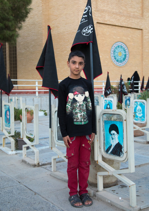 Portrait of an iranian shiite boy in the rose garden of martyrs cemetery, Isfahan Province, Isfahan, Iran