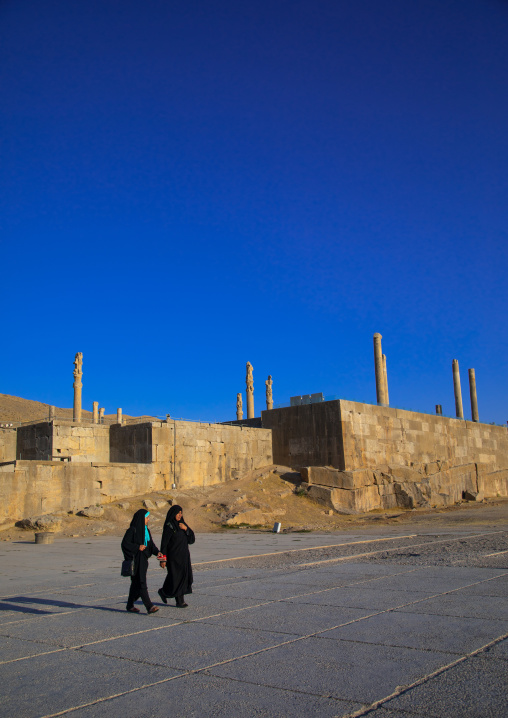 Two iranian women passing in front of the site of Persepolis, Fars Province, Marvdasht, Iran