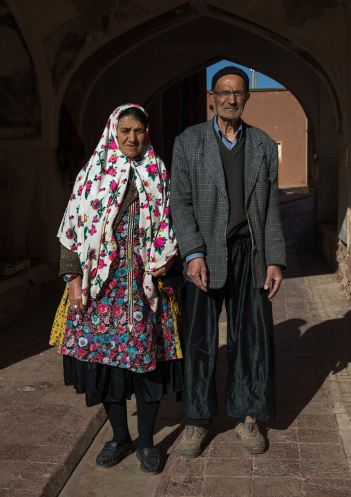 Portrait of an iranian woman wearing traditional floreal chador with her husband in zoroastrian village, Natanz County, Abyaneh, Iran