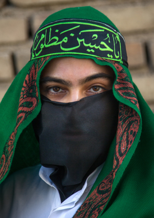 Iranian shiite muslim man with his face hidden by a veil mourning Imam Hussein on Tasua during the Chehel Manbar ceremony one day before Ashura, Lorestan Province, Khorramabad, Iran