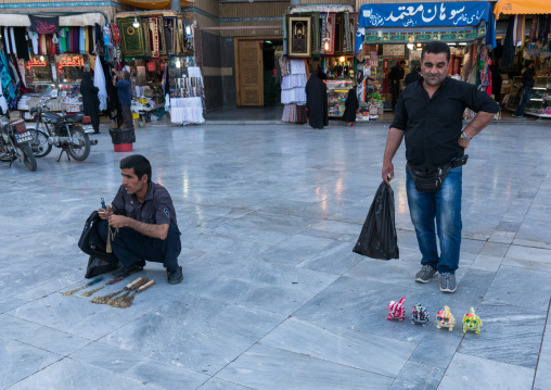Men selling iron chains for children and toys  in Fatima al-Masumeh shrine during Muharram, Central County, Qom, Iran