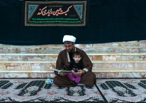 Mullah with his daughter in the Shrine of sultan Ali during Muharram, Kashan County, Mashhad-e Ardahal, Iran