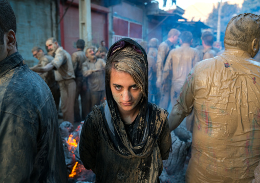 An iranian shiite muslim woman stands in front a bonfire after rubbing mud on her chador during the Kharrah Mali ritual to mark the Ashura day, Lorestan Province, Khorramabad, Iran