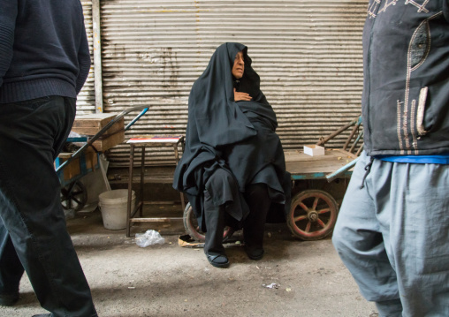 old woman sitting on a bench in the bazaar, Central district, Tehran, Iran