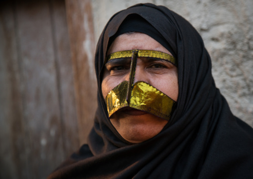 a bandari woman wearing a traditional gold mask called the burqa with a moustache shape, Qeshm Island, Salakh, Iran
