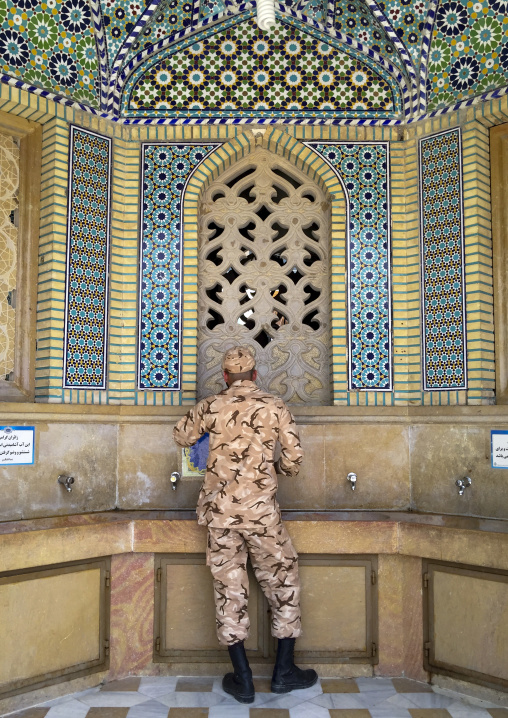 Soldier taking water at a fountain at the shah-e-cheragh mausoleum, Fars province, Shiraz, Iran
