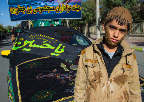 Iranian Shiite Muslim Boy Covered In Mud In Front Of A Decorated Car During Ashura, The Day Of The Death Of Imam Hussein, Kurdistan Province, Bijar, Iran