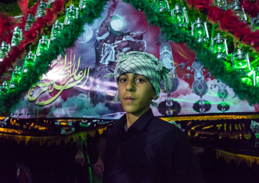 Iranian Shiite Muslim Boy Mourner Pausing Proudly In Front Of An Alam On Ashura, The Day Of The Death Of Imam Hussein, Isfahan Province, Kashan, Iran