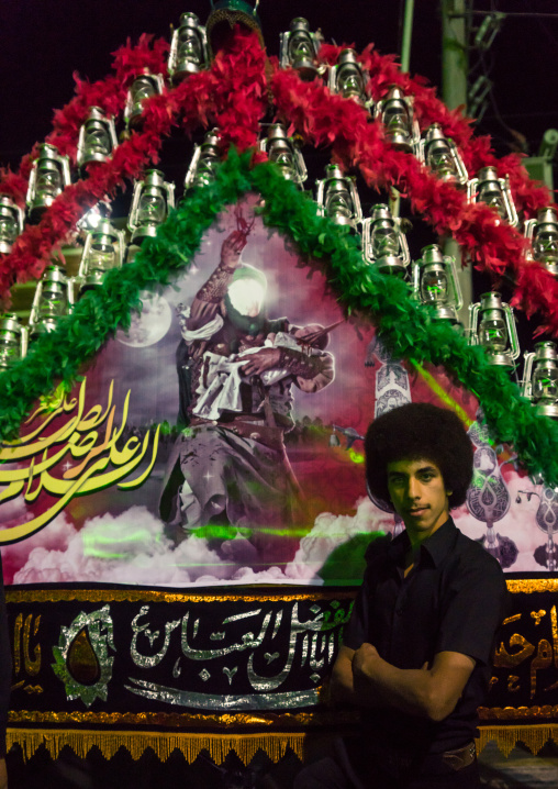 Young Iranian Shiite Muslim Man Mourner Pausing Proudly In Front Of An Alam On Ashura, The Day Of The Death Of Imam Hussein, Isfahan Province, Kashan, Iran