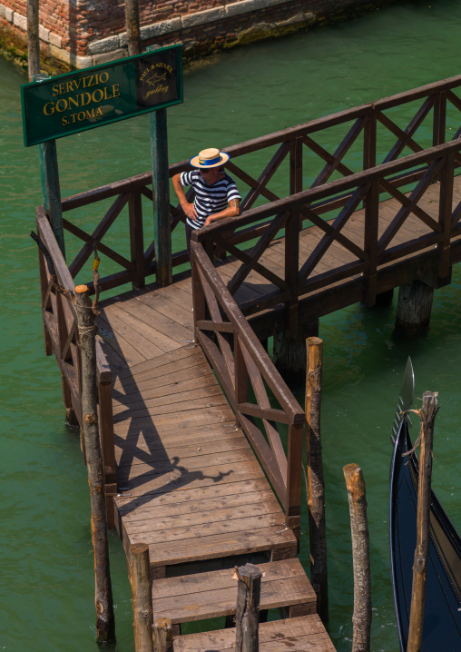 High angle view of a gondolier on a wooden pontoon, Veneto Region, Venice, Italy