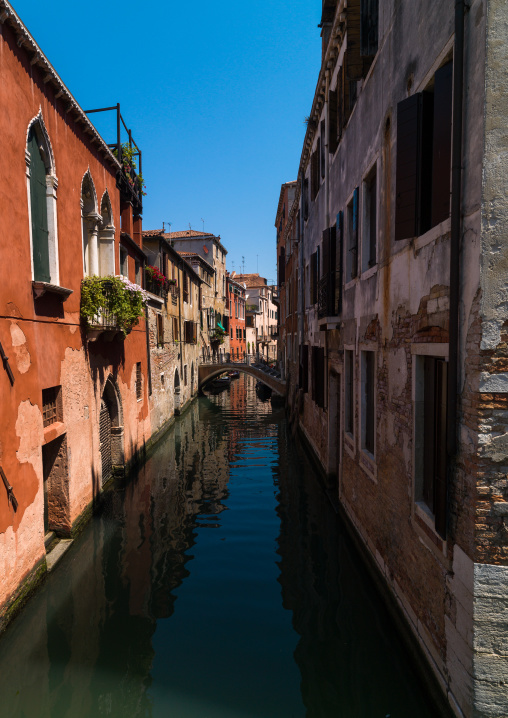 Venetian decayed facades and reflections on a canal, Veneto Region, Venice, Italy
