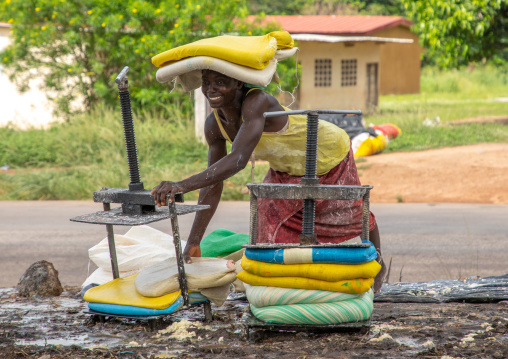 African woman putting attiéké in bags, Région des Lacs, Sakiare, Ivory Coast