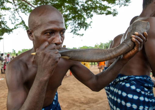 Musician blowing in a horn during a Goli mask dance in Baule tribe, Région des Lacs, Bomizanbo, Ivory Coast