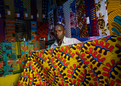 African seller with colorful african fabrics in a shop, Comoé, Abengourou, Ivory Coast