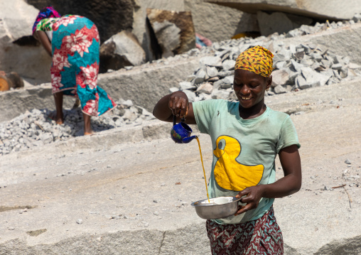 African woman preparing tea in a granite quarry, Savanes district, Shienlow, Ivory Coast