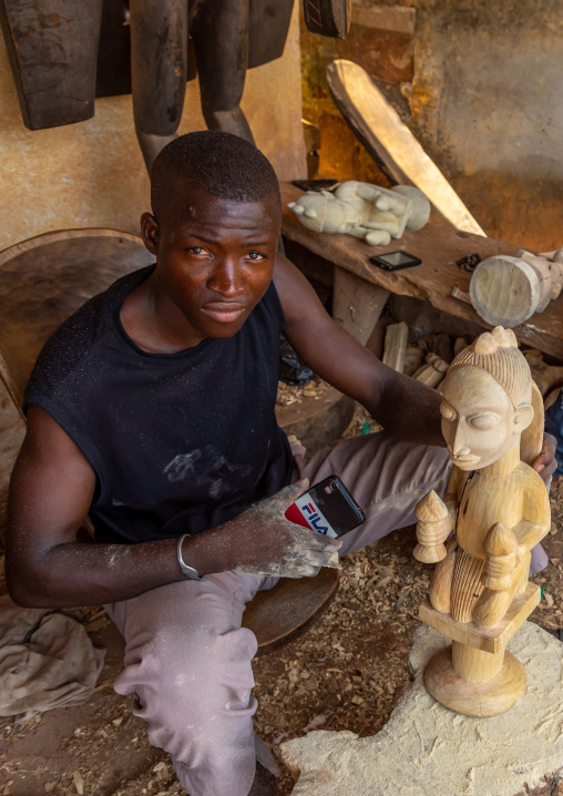 Master wood carver making a Senufo statue, Poro region, Korhogo, Ivory Coast