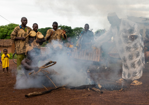 Shirtless man sitting in the fire during the Ngoro dance, Savanes district, Ndara, Ivory Coast