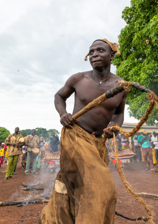 Young Senufo shirtless man dancing the Ngoro with a whip during a ceremony, Savanes district, Ndara, Ivory Coast
