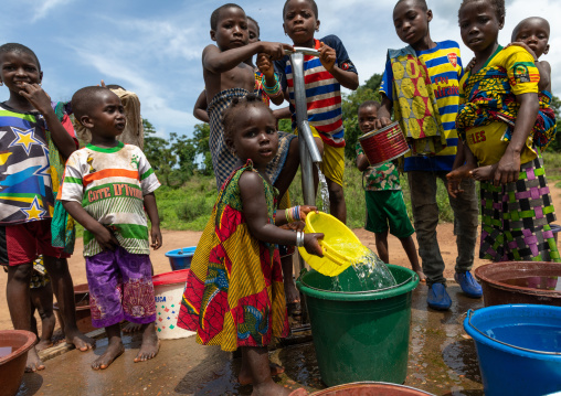 African children collecting water from a well with a pump, Bafing, Yo, Ivory Coast