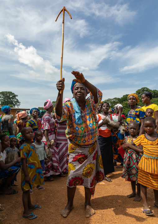 Dan tribe woman celebrating the yam harvest in a village and dancing with a wooden stick, Bafing, Godoufouma, Ivory Coast