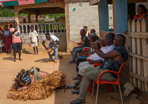 We Guere sacred mask resting in front of the village leaders during a ceremony, Guémon, Bangolo, Ivory Coast