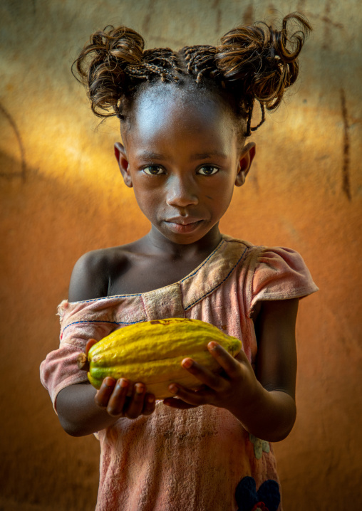Cute african girl with a cocoa fruit pod in her hands, Région des Lacs, Yamoussoukro, Ivory Coast