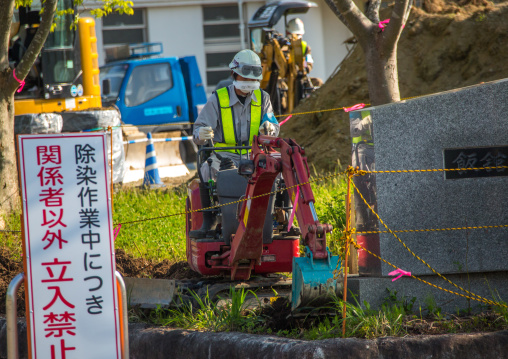 A sign warns people and workers remove top soil contaminated by nuclear radiations after the daiichi nuclear power plant explosion, Fukushima prefecture, Iitate, Japan