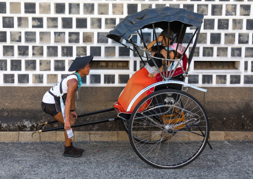 Rickshaw driver taking a picture of tourists in Bikan historical quarter, Okayama Prefecture, Kurashiki, Japan