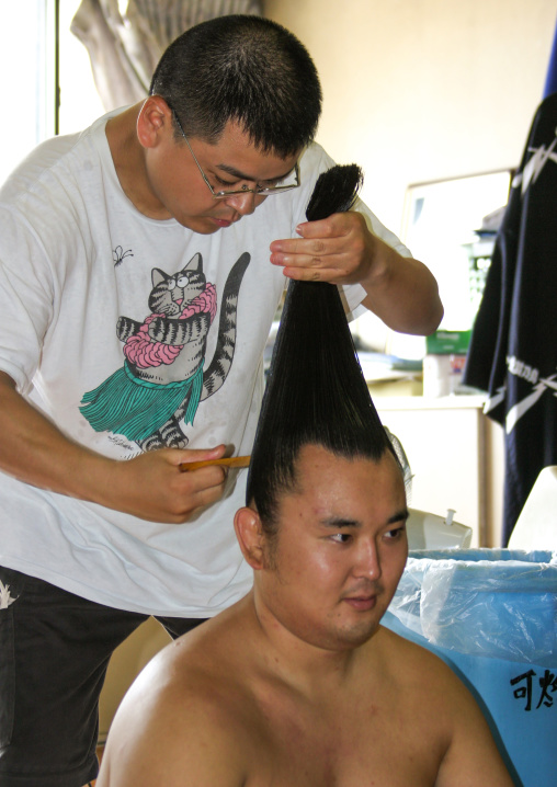 Hairdresser making a bun to a sumo wrestler, Kanto region, Tokyo, Japan