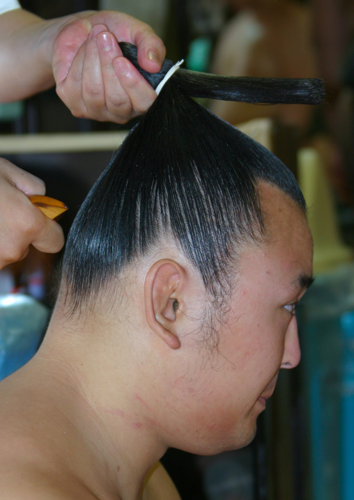 Hairdresser making a bun to a sumo wrestler, Kanto region, Tokyo, Japan