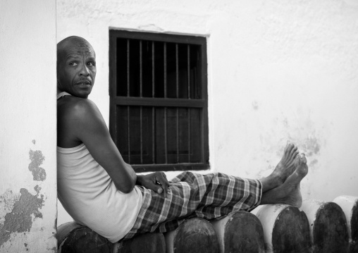 Man resting on a wall, Lamu County, Lamu, Kenya