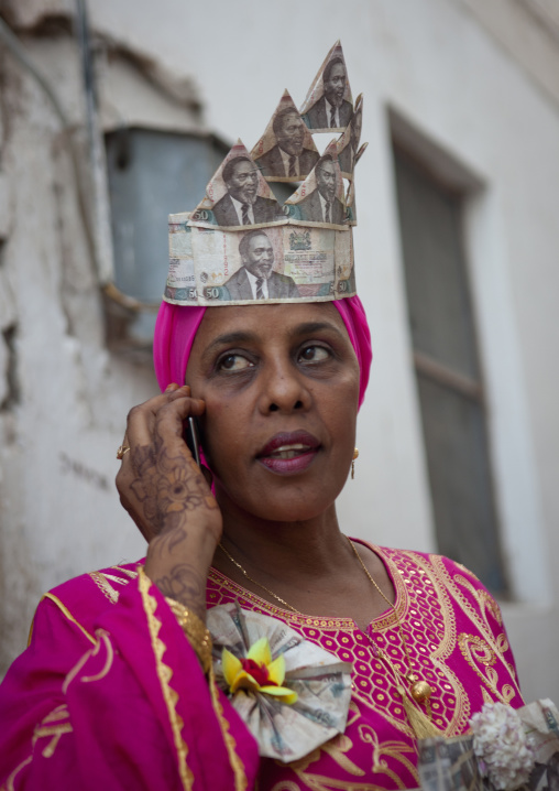 Woman wearing bank notes hat during Maulid festival, Lamu County, Lamu, Kenya