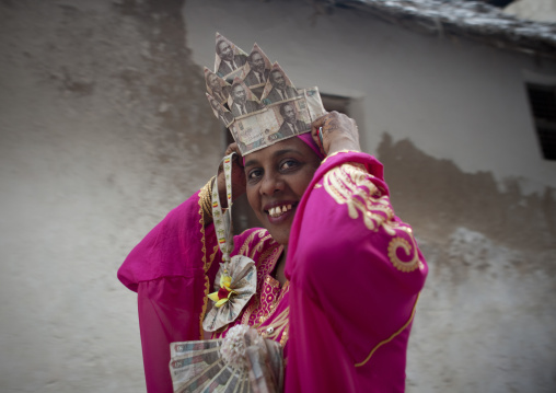 Woman wearing bank notes hat during Maulid festival, Lamu county, Lamu, Kenya