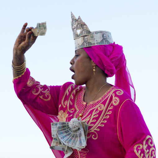 Woman wearing bank notes hat during Maulid festival, Lamu County, Lamu, Kenya
