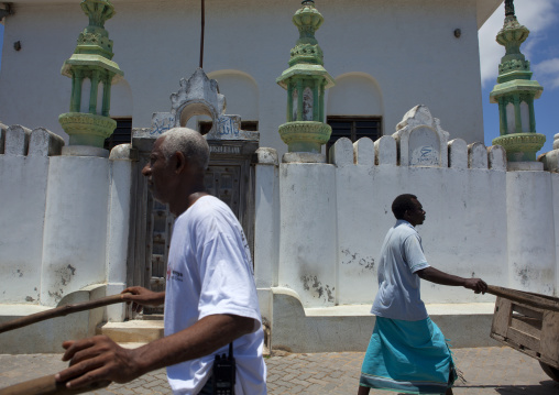 Men pushing their carts in front of a mosque, Lamu County, Lamu, Kenya