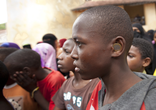 Teenage boy profile with money coin in ear, Lamu County, Lamu, Kenya