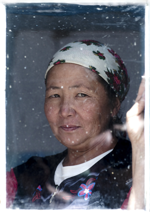 Woman With Headscarf Through A Window, Kyzart Village, Kyrgyzstan