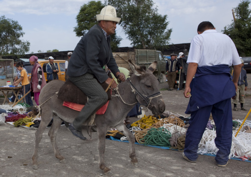 Old Man With A Kalpak Hat Riding A Donkey At The Animal Market Of Kochkor, Kyrgyzstan