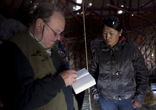 Reporter Taking Notes When Interviewing A Woman Under A Yurt, Saralasaz Jailoo Area, Kyrgyzstan